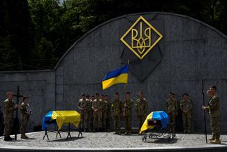 Украинские военнослужащие принимают участие в церемонии похорон своих товарищей, Ивана Кердмана и Сергея Сподаренко, которые недавно погибли в бою с российскими войсками