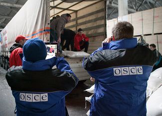 Наблюдатели ОБСЕ смотрят за тем, как разгружается российский «гуманитарный конвой» для жителей юго-востока Украины, 31 января 2015-го