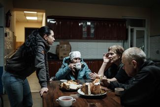 Жена Олега Евгения разговаривает с беженцами, прибывшими в благотворительный центр.4 мая 2022 года 