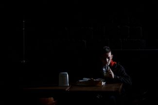 Житель Николаева пьет лимонад в темном кафе во время отключения электроэнергии