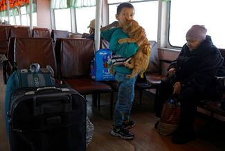 Мальчик держит на руках кошку во время «эвакуации» из Херсона