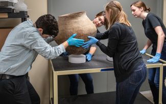 Аспиранты из Университета Индианы-Пердью в Индианаполисе работают с керамикой в помещении недалеко от Индианаполиса, где хранятся найденные артефакты.