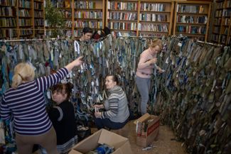 Volunteers prepare camouflage netting for the Ukrainian military at the Ivanychuk Library in Lviv