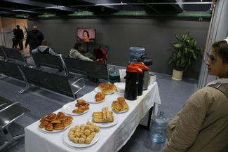 Пирожки, сладости и термосы с чаем в московском мобилизационном центре. Точное число человек, которое российские власти планируют призвать на военную службу, по-прежнему неизвестно
