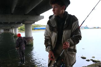 Саня и Дима рыбачат под мостом, соединяющим Озерновский и Запрожье
