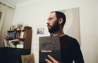 Stanislav Azarov holds an album of drawings by Foma Jaremtschuk. 2019