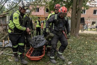 Rescuers transport the body of a victim of the Russian bombing in Kharkov