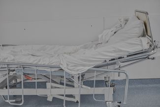An empty hospital bed in the hallway of the intensive care unit