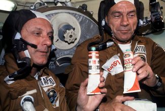 Астронавты Томас Стаффорд и Дональд Слэйтон с едой советских космонавтов. В тюбиках находился борщ, но на них были наклеены этикетки от водки.