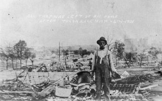 Житель Талсы на руинах собственного дома, сожженного участниками погромов