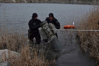 Украинские спасатели достают из озера в Запорожской области обломки российской ракеты