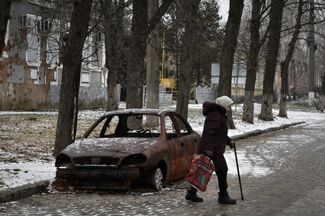 Жительница Орехова идет мимо сгоревшего автомобиля