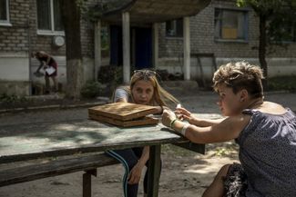 Жительницы Северска сидят во дворе дома после сильного обстрела города