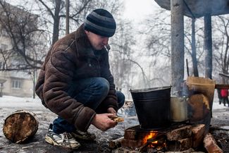 Locals have to melt snow on open fire as there is no electricity, gas or water. 30 January 2015.