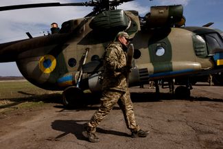 Военнослужащий 18-й бригады ВСУ несет один из снарядов, которыми оснащаются вертолеты подразделения