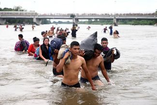 Мигранты переходят реку Сучьяте на границе Гватемалы и Мексики. 20 октября 2018 года