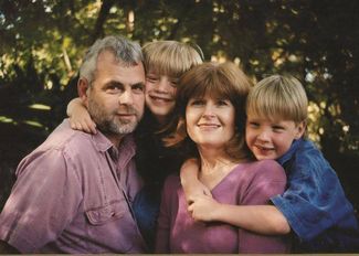 Алекс Гилберт (справа) со своими новозеландскими родителями и братом — тоже усыновленным