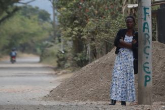 Жительница города Тимба рядом со столбом, на который нанесено название ФАРК. На этом месте взорвался заминированный автомобиль полиции. 13 августа 2023 года