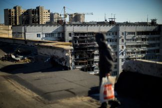 Житель харьковского района Салтовка на крыше поврежденной многоэтажки. Район на севере города подвергался регулярным артиллерийским обстрелам с февраля 2022 года