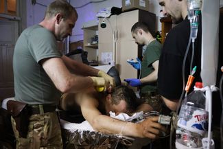 Медики оказывают помощь раненому украинскому военнослужащему. 
