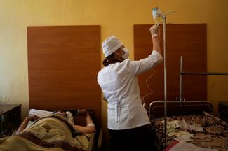 Медсестра ухаживает за пациентом, который был ранен, подорвавшись на мине в Северодонецке