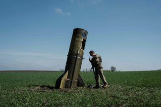 Украинский военный и остатки российской ракеты в селе Богодарово, Харьковская область