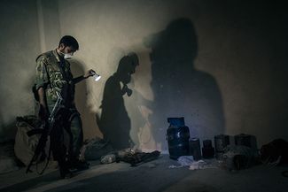Солдат сирийской армии показывает оружие, которое было найдено после атаки в одном из пригородов Дамаска, 24 августа 2013 года