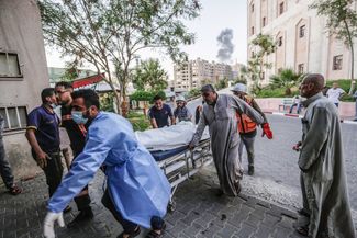 Тело палестинца, убитого во время авиаудара армии Израиля, везут в больницу Аль-Шифа. Город Газа, 13 мая 2021 года