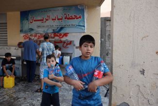 Палестинские подростки запасаются водой в Газе. Израильские власти заявили, что не будут оказывать гуманитарную помощь палестинцам, пока боевики ХАМАС не отпустят заложников, захваченных 7 октября во время нападения на Израиль. Из-за блокады в сектор Газа прекращена подача воды, электричества и топлива.