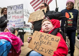 Демонстрация противников отмены Obamacare в Вашингтоне. Надпись на плакате в руках ребенка: «Я жив благодаря медицинской страховке»