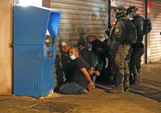 Израильские службы безопасности задерживают израильских арабов во время столкновений в городе Лод. 13 мая 2021 года