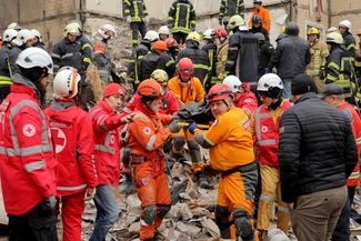 Rescue workers carry the body of a victim killed in the strike