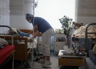 Медицинский работник в больнице Краматорска помогает женщине, которая получила ранения в жилом доме, разрушенном из-за ракетного удара. 2 февраля 2023 года.