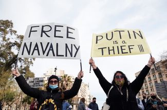 Протестующие с плакатами «Освободите Навального» и «Путин — вор» в Барселоне