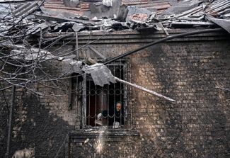 Киев, 11 декабря 2023 года. Женщина убирается в доме, поврежденном в результате российского обстрела