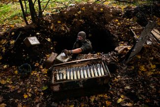 Украинский сапер собирает брошенные российскими военными боеприпасы во время разминирования Граково