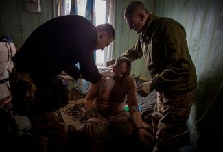 Украинские военные врачи с раненным бойцом ВСУ на передовой в Донецкой области