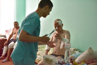 Один из пострадавших во время российской атаки получает медицинскую помощь
