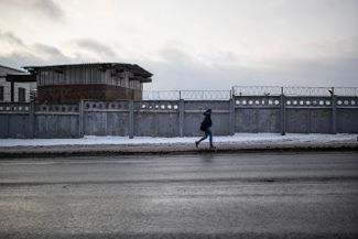 Dasha walks past a fence with barbed wire on her way to work. Before, this place always reminded her of the prison, but she’s grown used to not paying it any mind.