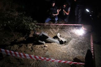 Журналисты фотографируют остатки ракетного снаряда во время пограничных столкновений Армении с Азербайджаном в городе Джермук. Армения, 15 сентября 2022 года
