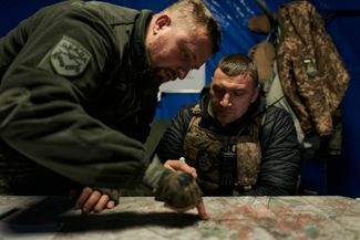 Украинские военнослужащие в командном центре в Бахмуте изучают карту района боевых действий