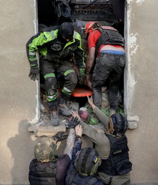 Rescuers pull out a wounded man from the rubble of an apartment building in Kharkov