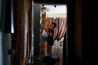 Жители Херсона пытаются спасти важные вещи в своих домах и домах своих друзей от наводнения. 7 июня 2023 года