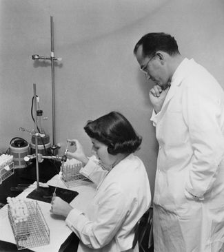 Создатель вакцины от полиомиелита Джонас Солк вместе с лаборанткой в медицинской школе Питтсбургского университета
