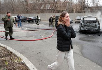Женщина после недавнего обстрела дома в подконтрольном сепаратистам Донецке, 28 февраля 2022 года