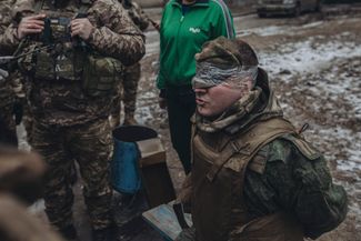 Украинские военные обыскивают пленного солдата армии РФ