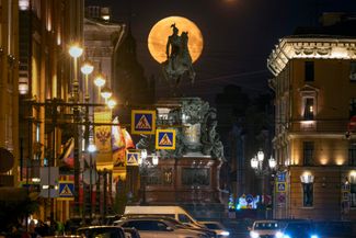 The moon rises over an equestrian monument to Russian Tsar Nicholas I in St. Petersburg. May 25, 2024.