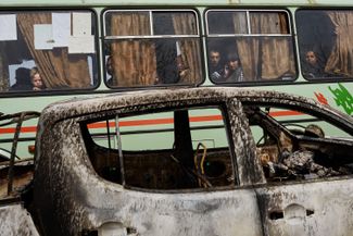 Residents drive past a burned out vehicle after fighting between Russia-backed fighters and Ukrainian forces in Sloviansk. April 20, 2014.
