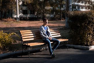 Николай на скамейке, где он ждал скорую после ранения