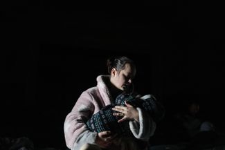 Женщина с ребенком на руках в бомбоубежище в Мариуполе